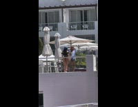 Woman black swimsuit bandana railings white umbrella