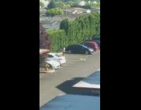 Woman hula-hoop practice tripod camera parking lot