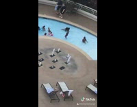 Girl watches lady do handstand hotel pool