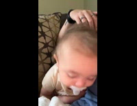 Mom rub forehead of baby fall asleep