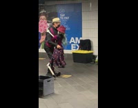 Guy salsa dances with a skeleton subway performer