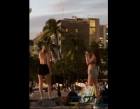 Woman in green bra poses at the beach at sundown