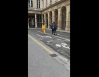 Woman in yellow outfit walks in the middle of the street