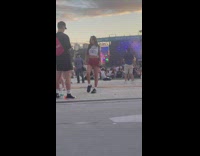 Woman in white crop top poses at a music festival