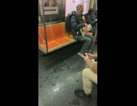 man carving wooden figure on train