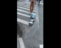 Man controls toy car cross the street