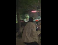 people on street fight with roman candle fireworks