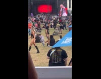 Woman bikini walks while man films behind