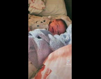 Baby smiles at cameraman as cameraman talks