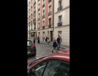 Woman black suit spots building window railings
