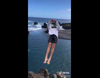 Guy attempts backflip falls headfirst towards rock