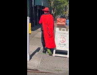 Man walks around wears red maga cape