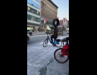 Man balance tire on head while biking
