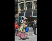 Person wears hat with feathers and vest