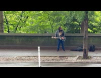 Man play electric guitar while raining park