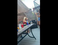 Red shirt girl sits blows bubbles balcony 