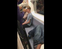 Guy sleeping on blue seats subway train rush hour
