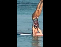 Headstand on board in water 