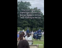 White gown girl graduate walks to parking lot