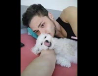 guy black shirt laying down kissing poodle 