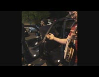 Guy plays banjo to hip hop song in car parking lot