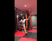 Man sweeps gym mat then man splits