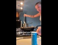 Woman cooks with two pan in kitchen