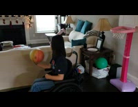 Little girl in wheelchair shoots baskketball backwards 