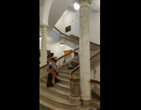 Woman white hat sit middle of stairs