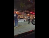 Woman in crop top leather pants tiktok on the street