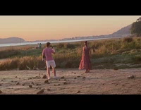 Woman in brown dress swings skirt at fields at sunset