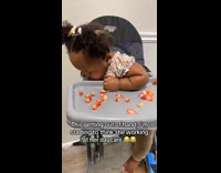 Sleepy young girl on high chair with strawberries