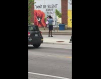 Dancer in pink shirt performs street mural