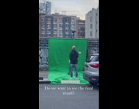 Man recording a music video on green screen set up on sidewalk