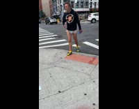 Black sweater guy holds two cans sidewalk 