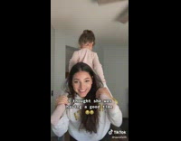 Mom carries her daughter on her shoulders