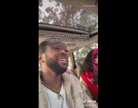 Guy driving car puts arm over friend 