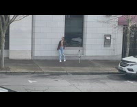 Girl brown coat walk back forth wall