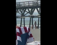 Girl kneel lean forward under bridge beach