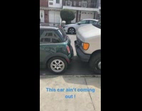 green mini cooper stuck between two cars 