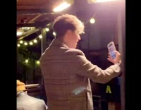 Guy brown coat fix hair selfie light 