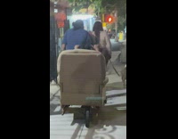 Person rides scooter with lounge chair 