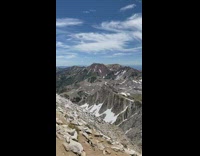 Guy top of mountain plays trumpet instrument 