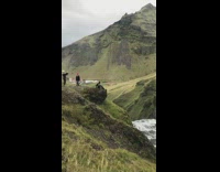 Girl black coat sit on ledge waterfalls