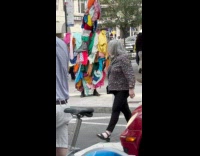 Collab WINY - Person in clothes dumpster costume at sidewalk