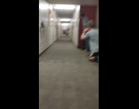 Man throws and rolls the lid in the college dorm hallway