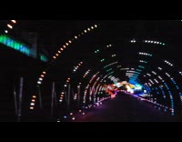 Car drives through colorful christmas lights tunnel 