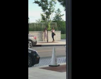 Woman white top pose wall grills sidewalk photo shoot