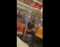 Man in black shirt sits beside the poster that looks like him