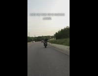 Guy riding motorcycle leans head to side 